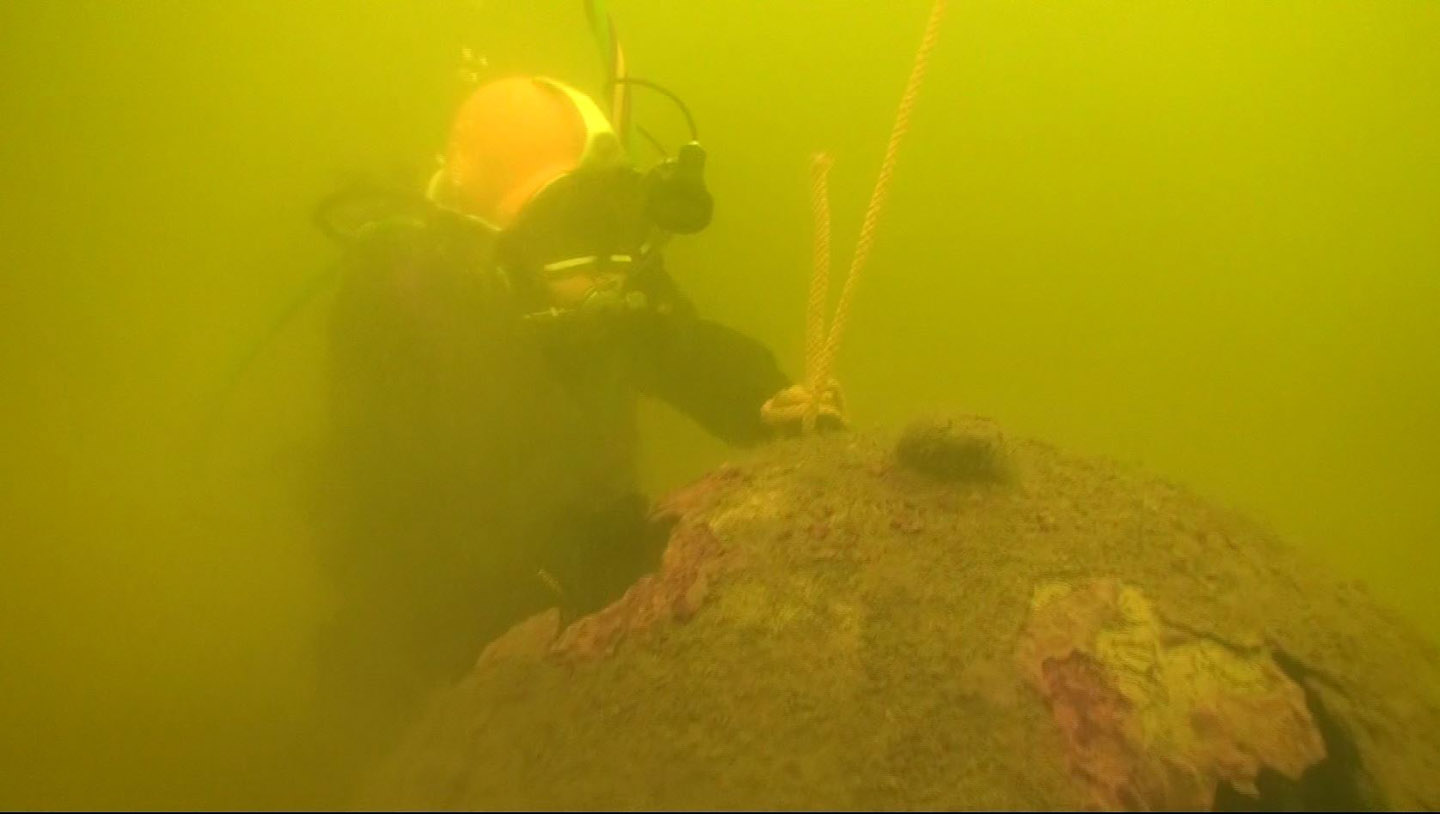 Diver recovering a discarded German WW II moored mine