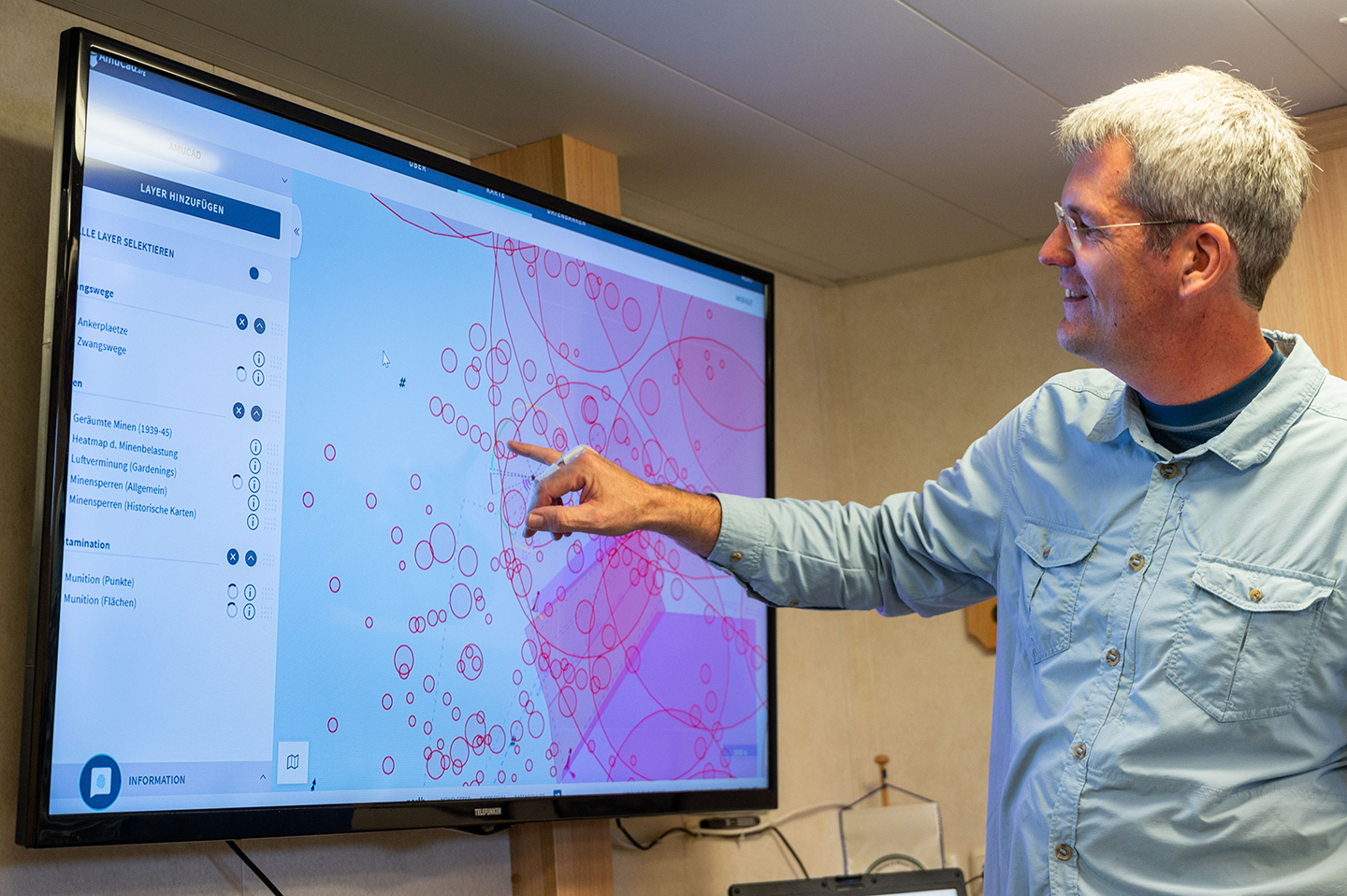 Claus Böttcher shows the interactive map amucad.org, where locations of airborne sea mines from WW II are indicated.